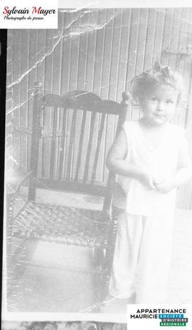 Enfant à côté d'une chaise